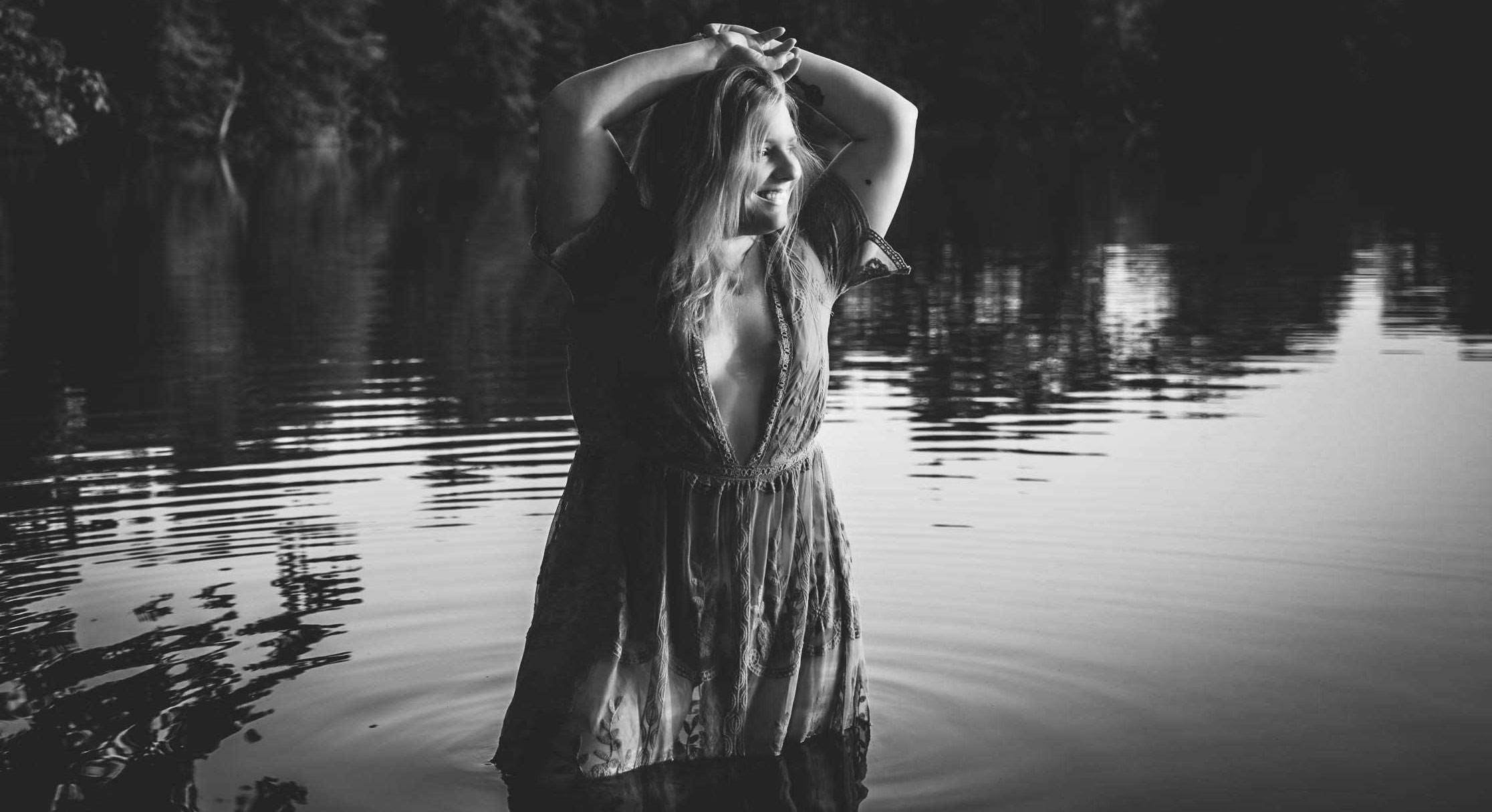 photograph of woman standing in lake